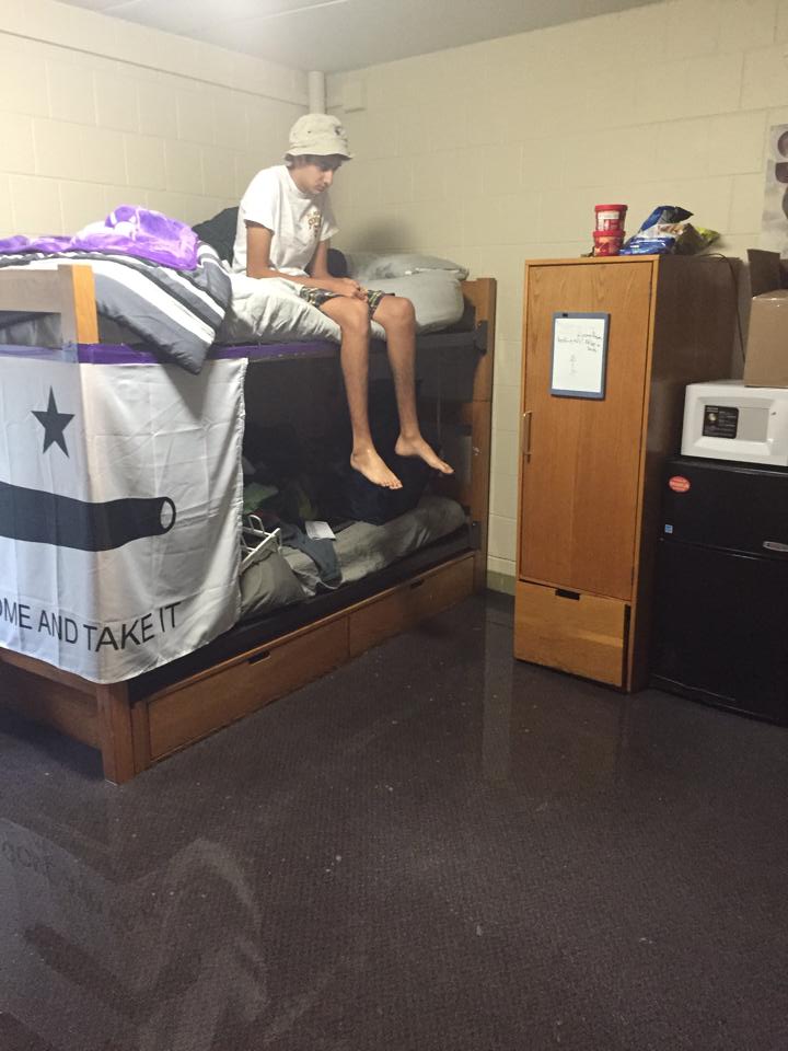 Weinberg Freshman  Nabeel Muscatwalla looks down from his lofted bed at the half an inch of standing water on his bedroom floor in PARC.